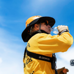 Imagem de arquivo — membro de busca e salvamento do Joshua Tree National Park bebe água durante o calor do verão. A fotografia não integra o relatório.